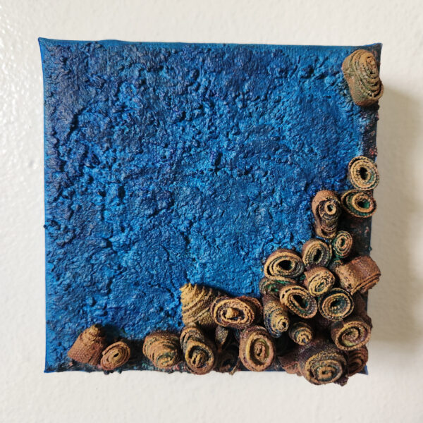 mixed media art. Textured blue with attachments giving a greater 3D effect.