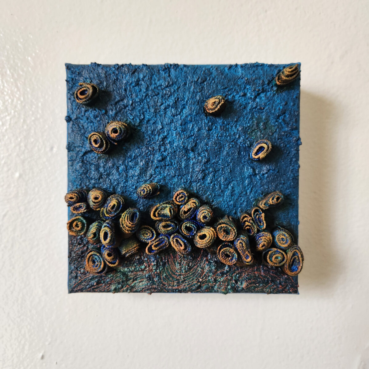 mixed media art. Textured blue with attachments giving a greater 3D effect.
