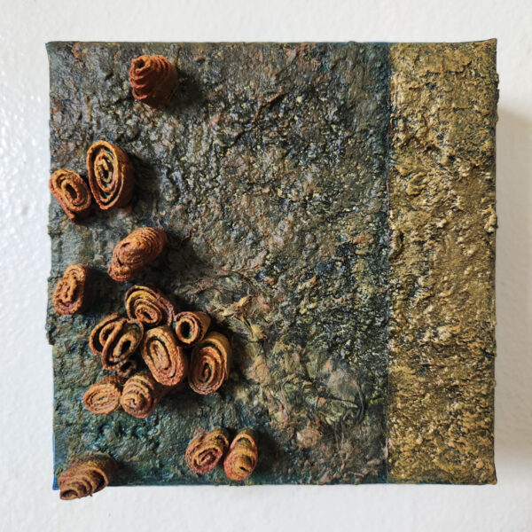 mixed media art. Textured green and gold with attachments giving a greater 3D effect.