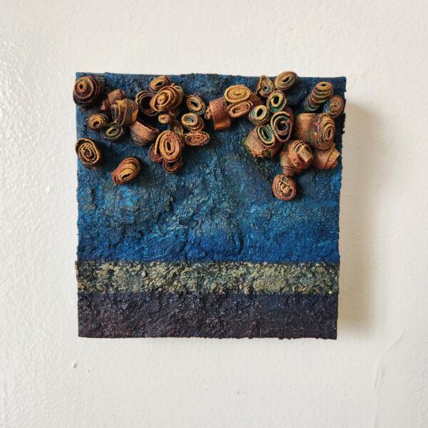 mixed media art. Textured blue with attachments giving a greater 3D effect.