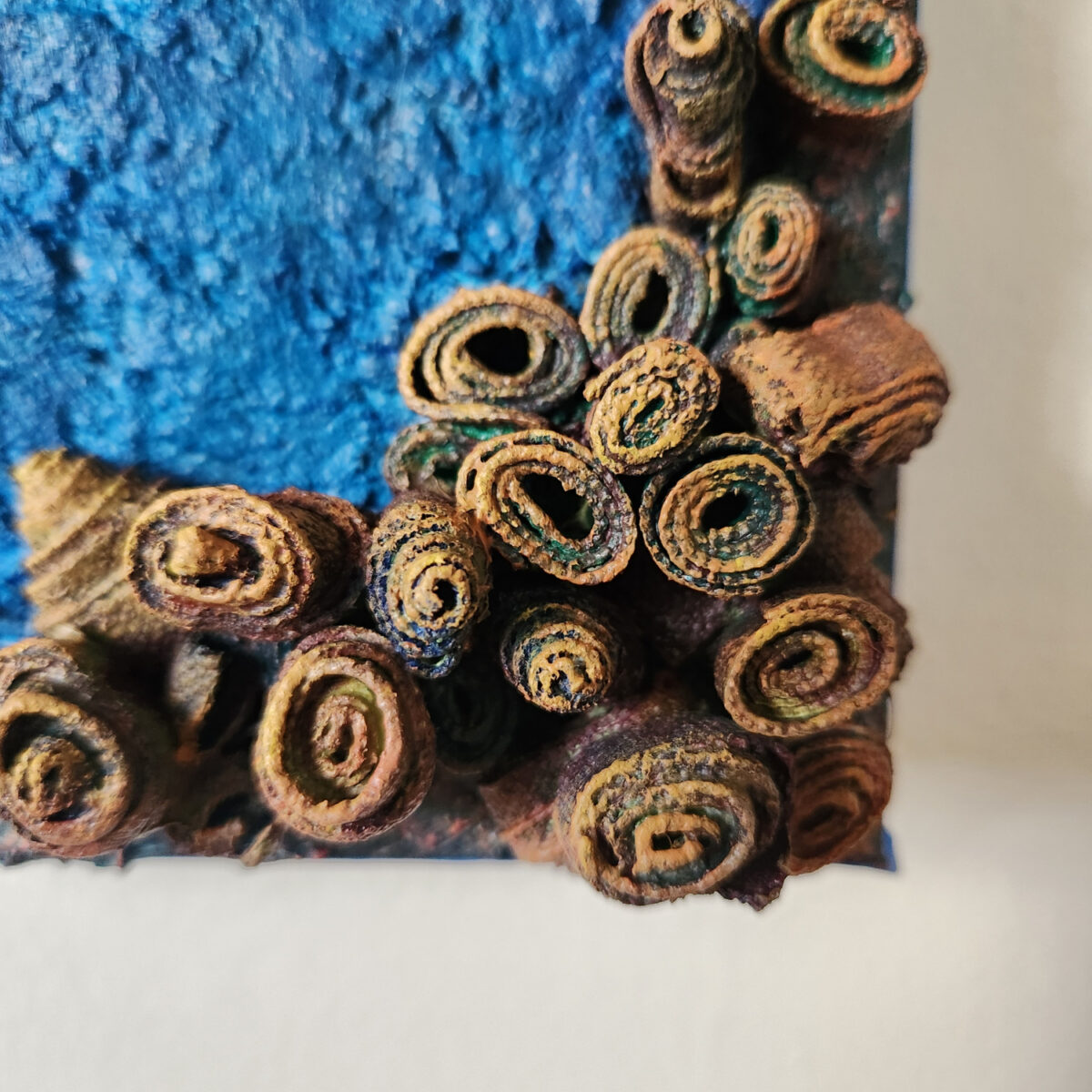 mixed media art. Textured blue with attachments giving a greater 3D effect.