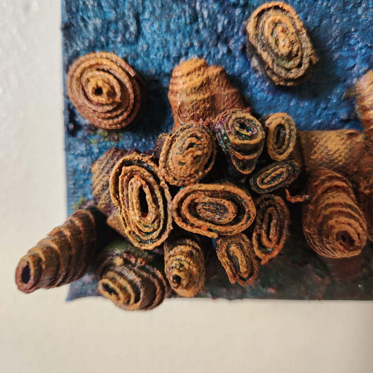 mixed media art. Textured blue with attachments giving a greater 3D effect.