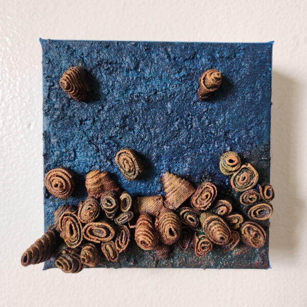 mixed media art. Textured blue with attachments giving a greater 3D effect.