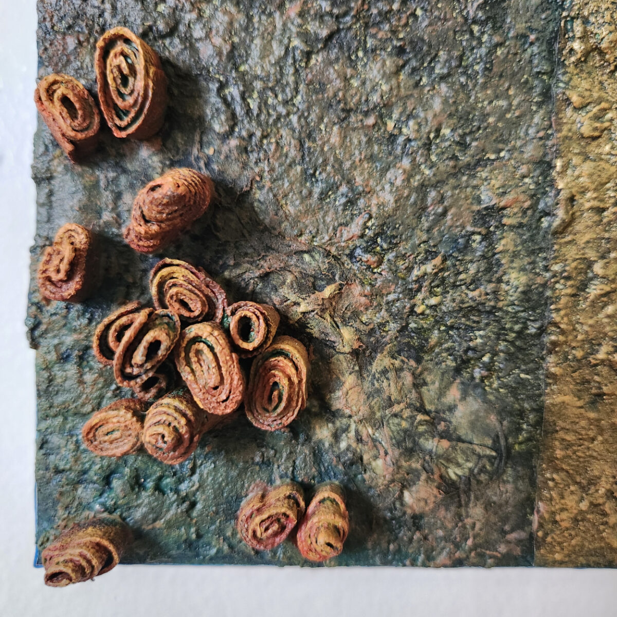 mixed media art. Textured green and gold with attachments giving a greater 3D effect.