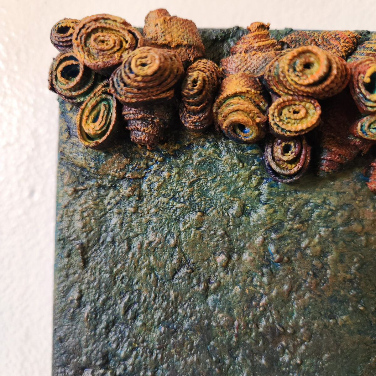 mixed media art. Textured green with attachments giving a greater 3D effect.