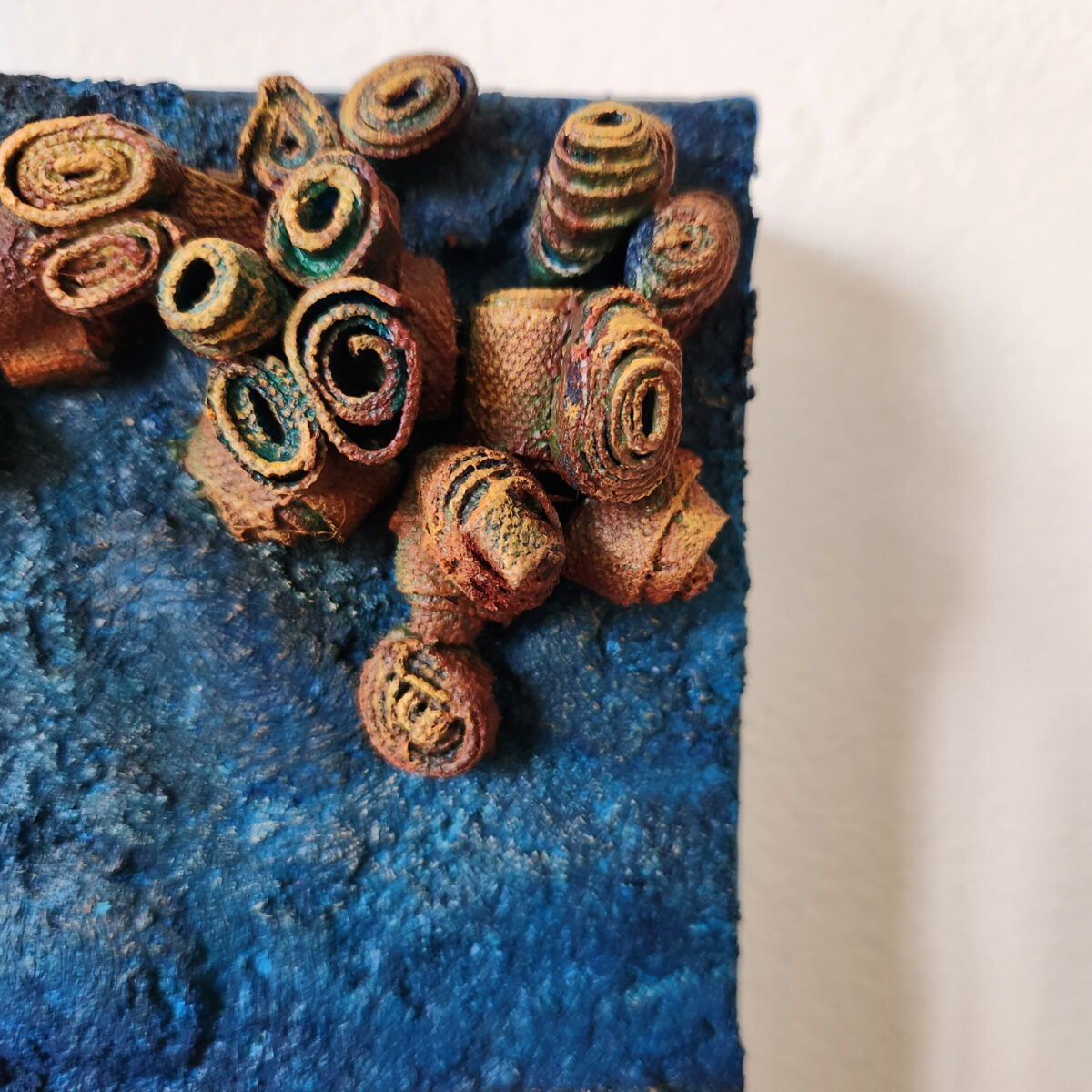 mixed media art. Textured blue with attachments giving a greater 3D effect.