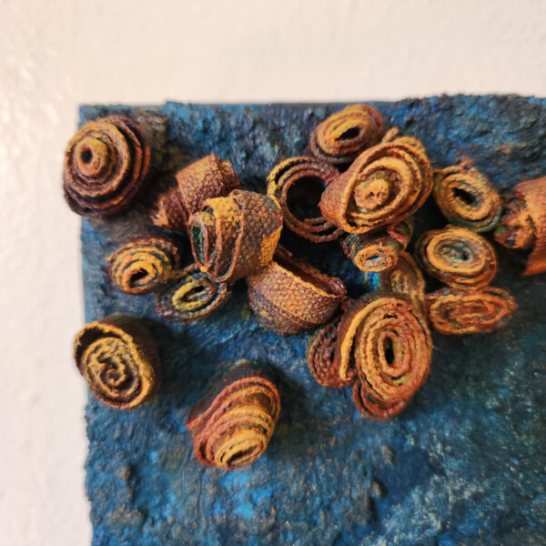 mixed media art. Textured blue with attachments giving a greater 3D effect.