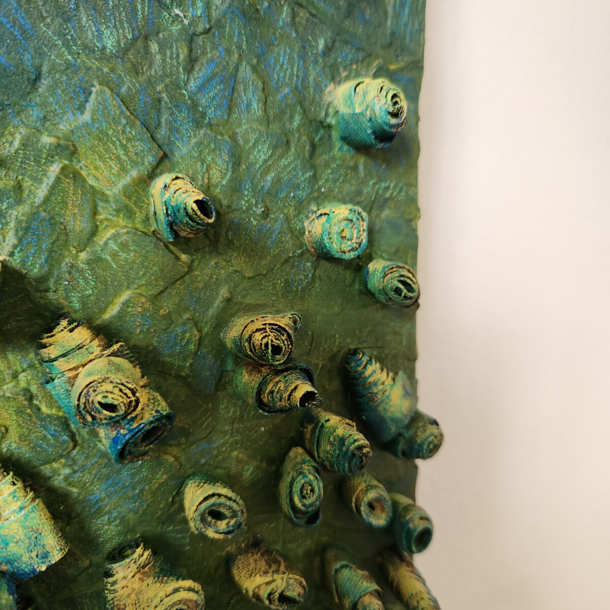 mixed media art. Textured green with attachments giving a greater 3D effect.