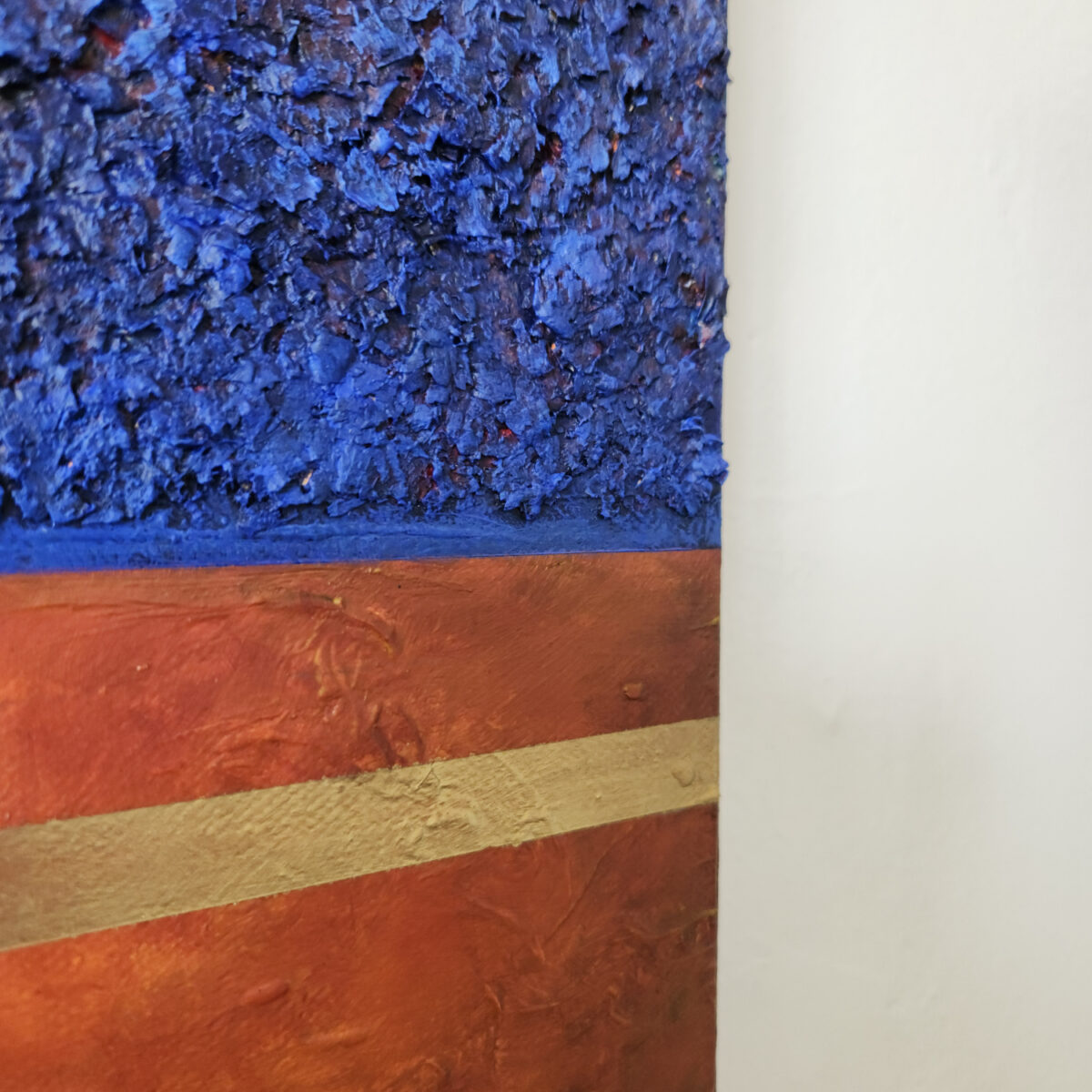 detail picture. Mixed Media art. Three sections total. top and bottom are blue textured sections. middle is aged orange with two lines of gold near top and bottom.