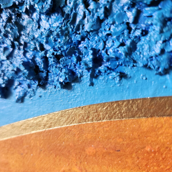 Detail picture. Mixed Media art. Blue texture with light blue elliptical border towards the bottom right. bottom right is aged orange.